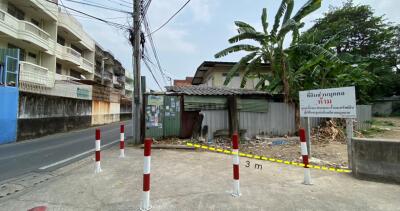 Urban street view showcasing an undeveloped lot with surrounding buildings and infrastructure