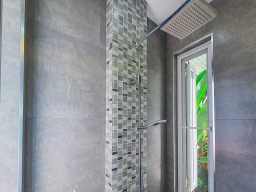 Modern bathroom with a walk-in shower featuring decorative mosaic tiles