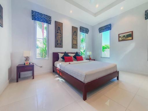 Spacious bedroom with a king-sized bed and white tiled flooring