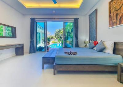 Spacious and well-lit bedroom with direct pool view