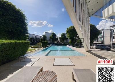 Luxurious outdoor swimming pool with lounging chairs and clear blue sky
