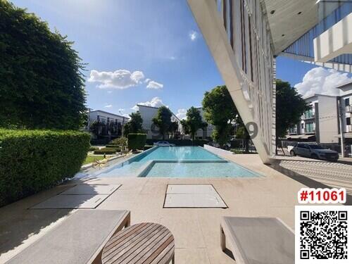 Luxurious outdoor swimming pool with lounging chairs and clear blue sky