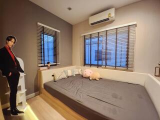 Cozy modern bedroom interior with a large bed and furnishings at dusk