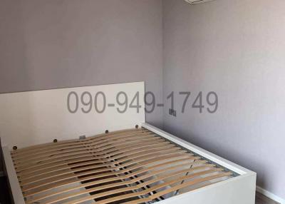 Minimalist bedroom with an unassembled bed and air conditioning unit