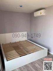 Minimalist bedroom with an unassembled bed and air conditioning unit