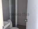 Compact bathroom with glass shower and white toilet