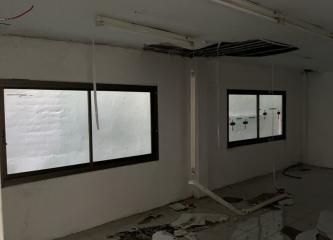Unfinished interior space with large windows and exposed wiring
