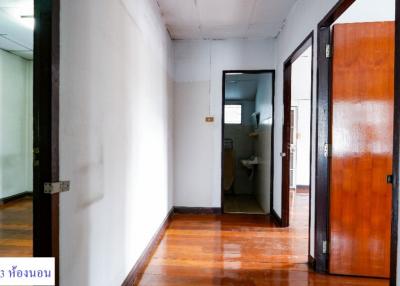 Spacious hallway with polished wooden floors and multiple doors leading to different rooms