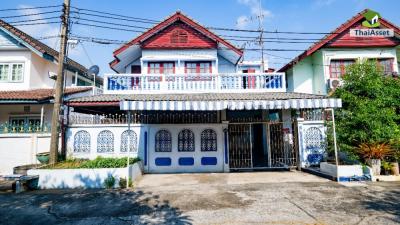 Traditional two-story house with blue accents under a clear blue sky