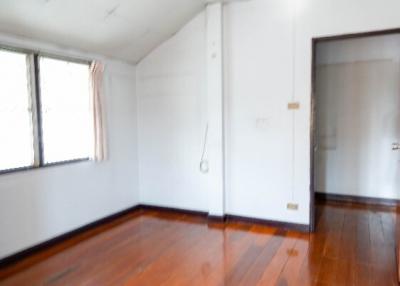 Spacious bedroom with wooden floors and natural light