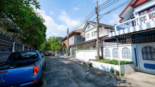 Suburban street view with residential buildings and parked car