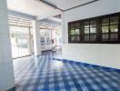 Spacious and well-lit tiled porch area with large windows and white walls