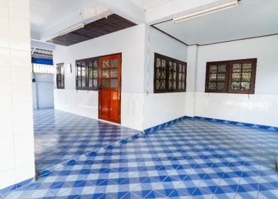 Spacious interior room with blue-patterned tiled flooring and ample natural light