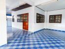 Spacious interior room with blue-patterned tiled flooring and ample natural light