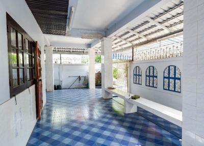 Bright and spacious covered veranda with blue patterned tiles and white columns