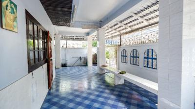 Bright and spacious covered veranda with blue patterned tiles and white columns