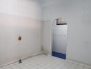 Empty white and blue tiled bathroom with visible plumbing installations