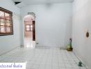 Empty white tiled room with windows and arched doorway