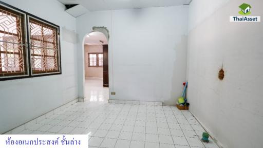 Empty white tiled room with windows and arched doorway