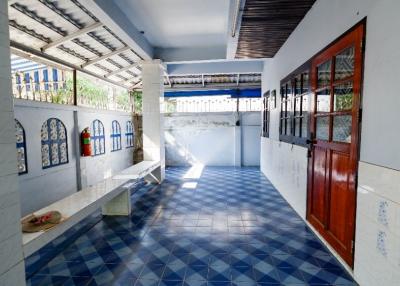 Brightly lit corridor with blue tiled floor and white walls
