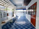 Brightly lit corridor with blue tiled floor and white walls