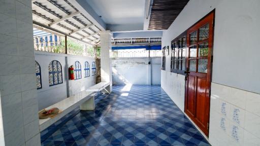 Brightly lit corridor with blue tiled floor and white walls