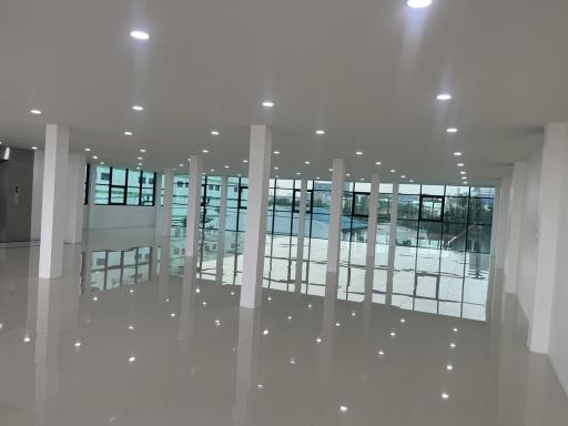 Modern spacious interior of a commercial building with reflective flooring and large windows