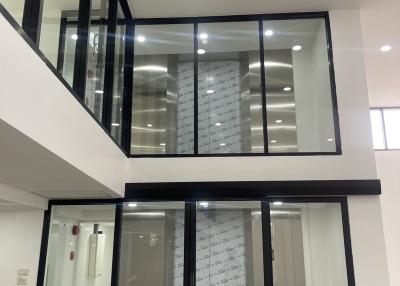 Modern two-story building interior with glass partitions and LED lighting