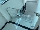 Modern staircase with chrome banisters and marble flooring