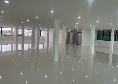 Spacious unfurnished interior of a modern building with glossy floor tiles and ample lighting