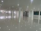 Spacious unfurnished interior of a modern building with glossy floor tiles and ample lighting