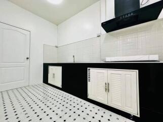 Modern kitchen with black countertops and geometric patterned floor