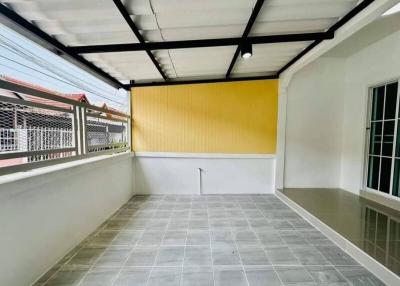 Enclosed patio area with tiled floor and bright yellow wall