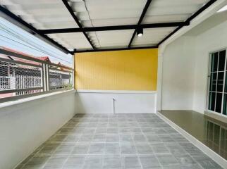 Enclosed patio area with tiled floor and bright yellow wall