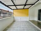 Enclosed patio area with tiled floor and bright yellow wall