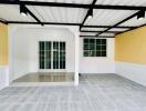 Empty living space with gray flooring and yellow walls