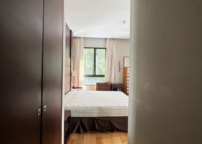 Cozy bedroom with wooden floor and large window