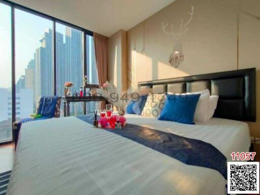 Modern bedroom with a large bed, city view, and decorative elements