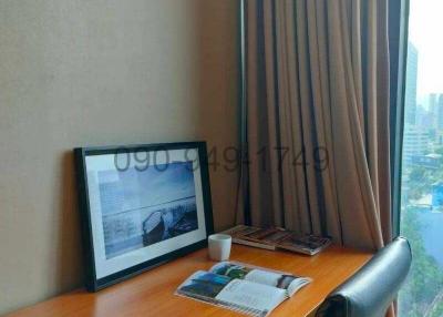 Cozy office nook with a wooden desk, chair, and a large window with a city view