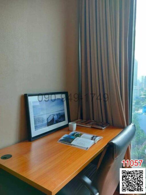 Cozy office nook with a wooden desk, chair, and a large window with a city view