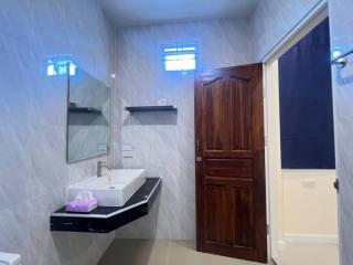 Modern bathroom with wooden door and black countertop