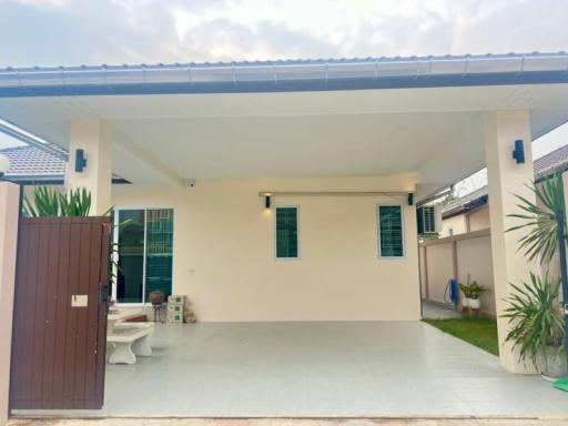 Front view of a modern house with carport and lawn