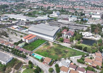 Aerial view of a mixed urban area showing residential buildings, commercial structures, and green space