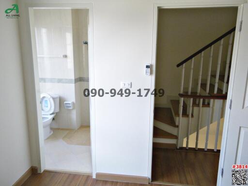 Interior view showing a bathroom door open and staircase in a building