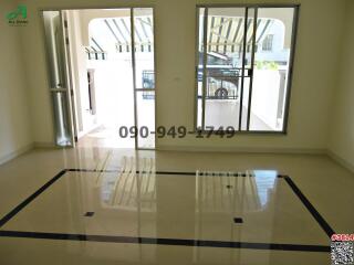 Spacious unfurnished living room with large windows and glossy tiled flooring