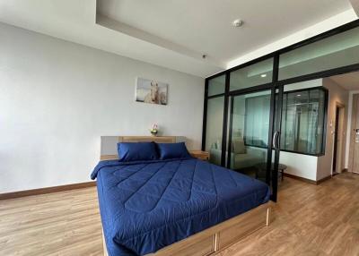 Modern bedroom with large bed and glass partition