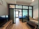 Modern living room interior with glass partition leading to a bedroom