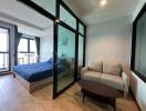 Modern bedroom with a comfortable sofa and glass partition