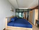 Cozy bedroom with wooden bed frame and glass partition leading to balcony