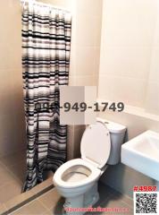 Compact bathroom with white ceramics and striped shower curtain